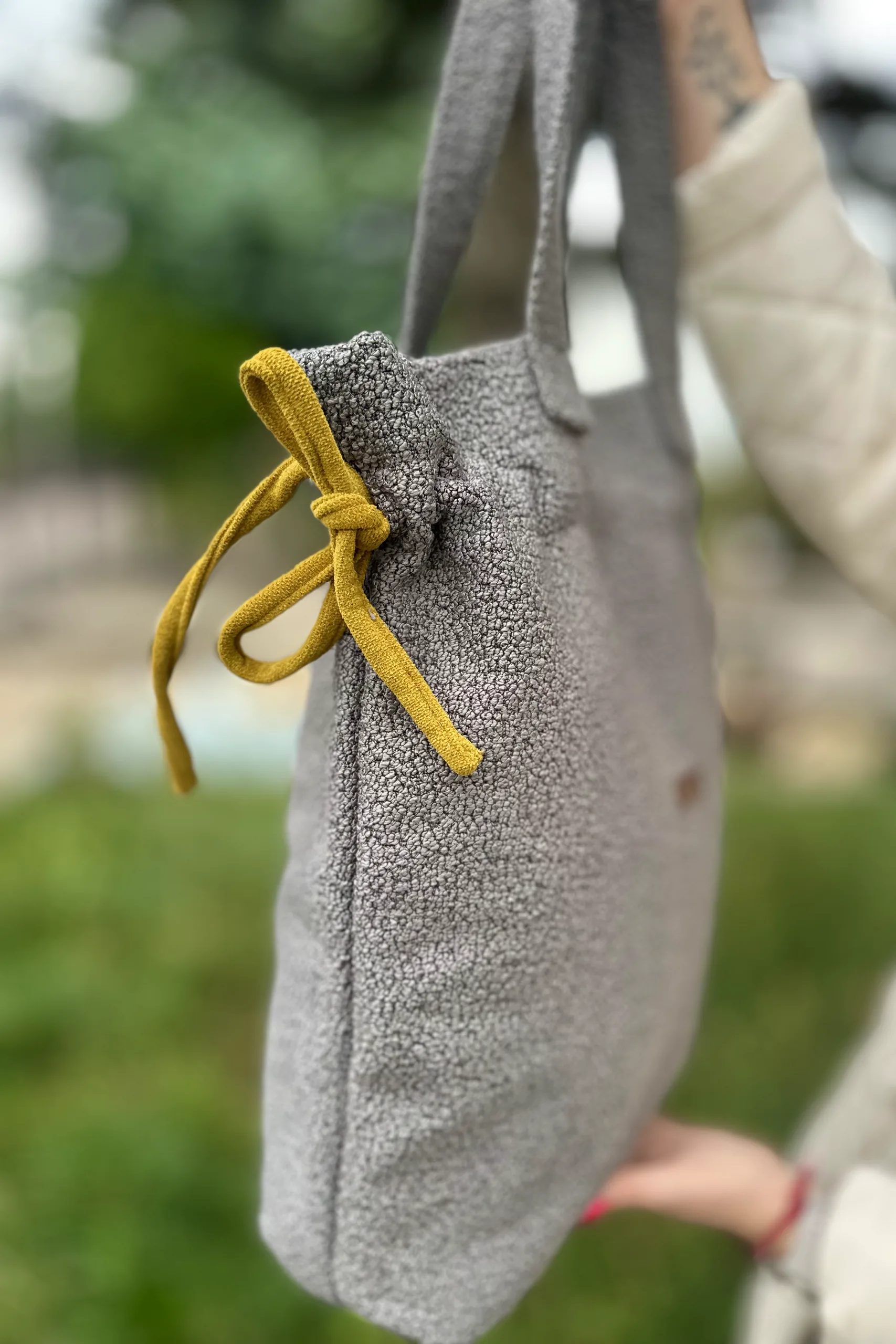 Szara shopperka z tkaniny boucle 3 Bok szarej shopperki z boucle z musztardowym sznurkiem, zbliżenie